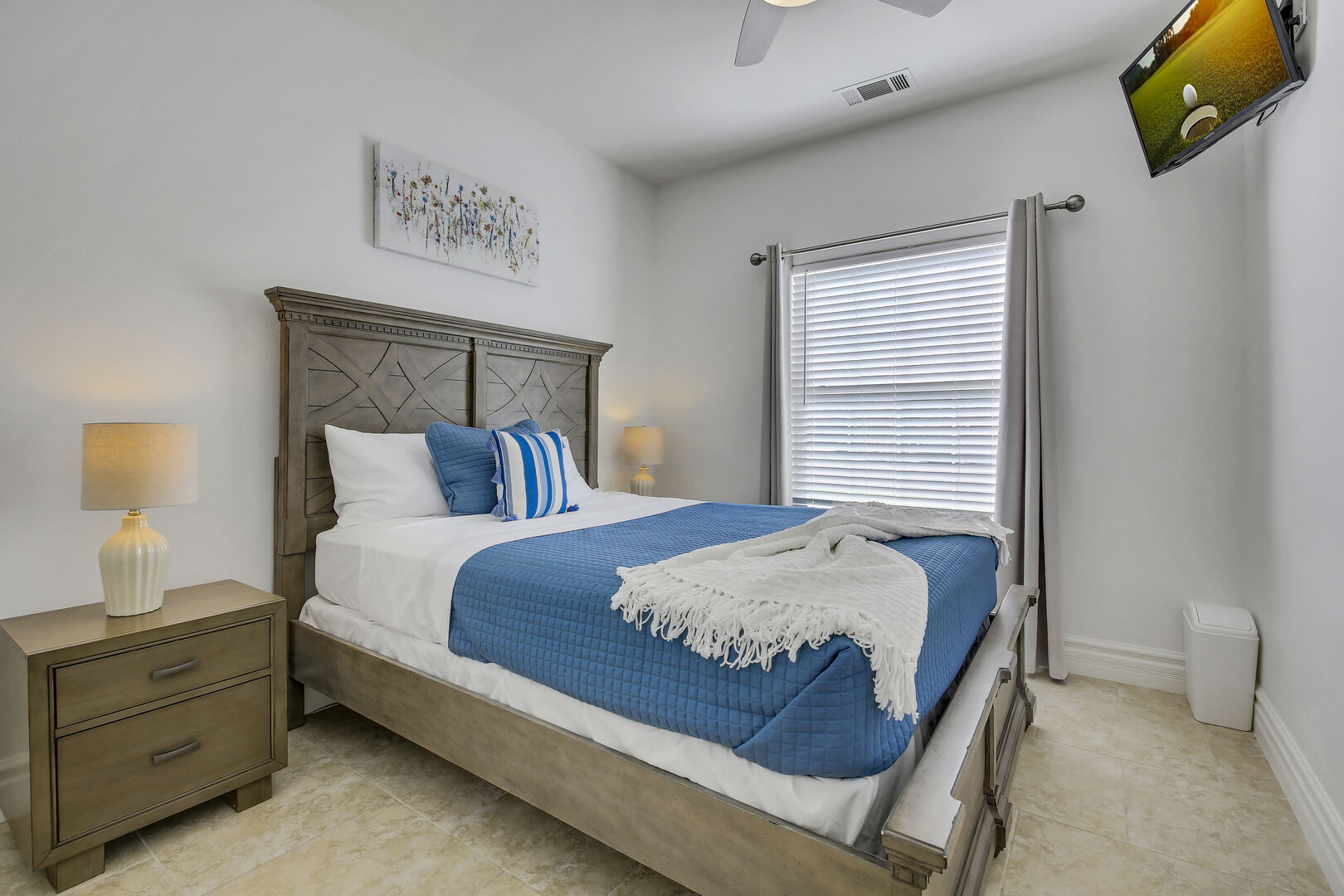 Bedroom 4 is located across the hallway bathroom and features a Queen-sized Bed, 32-inch Insignia Smart television, remote-controlled ceiling fan, and reach-in closet.