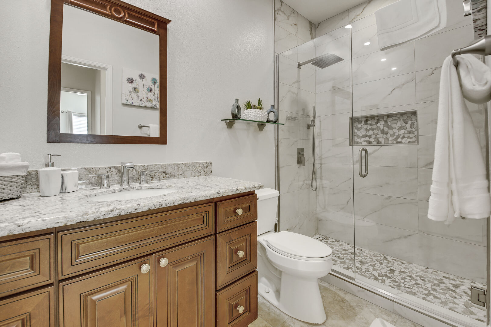 The hallway bathroom is located across bedroom four and features a tile shower and a vanity sink.