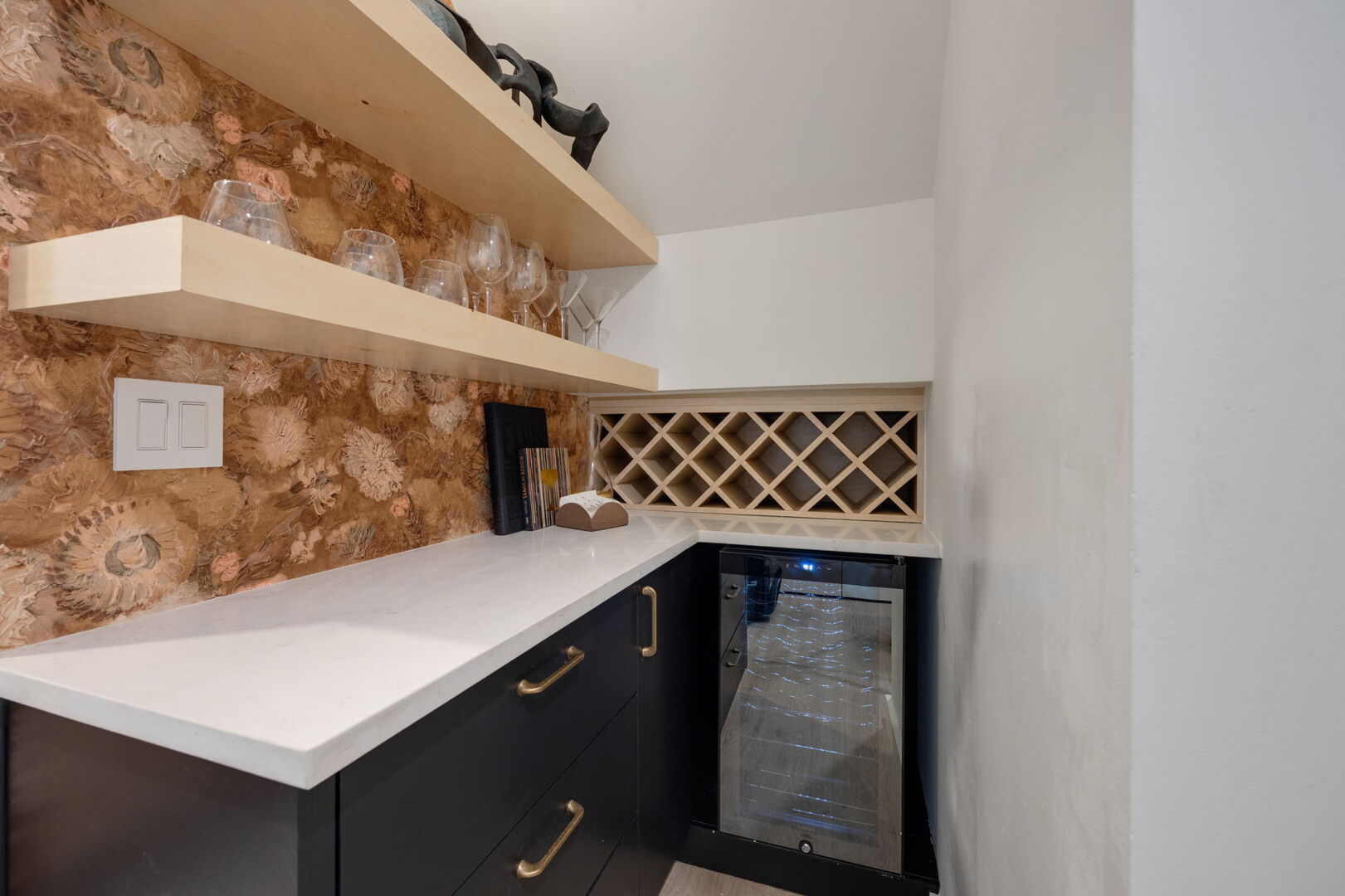 Main Level: Mini bar area under the stairs with a small fridge.