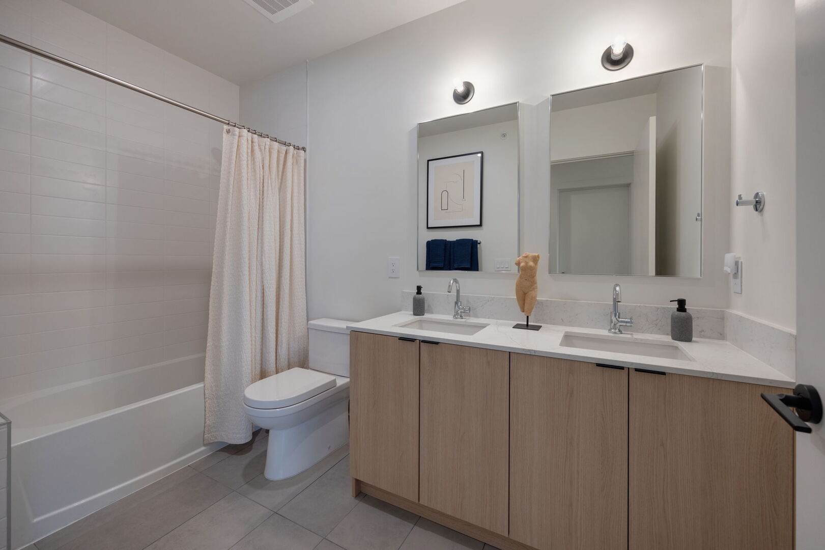 Upper Level: Primary bathroom with en-suite bedroom, shower/tub combo, and double vanities.