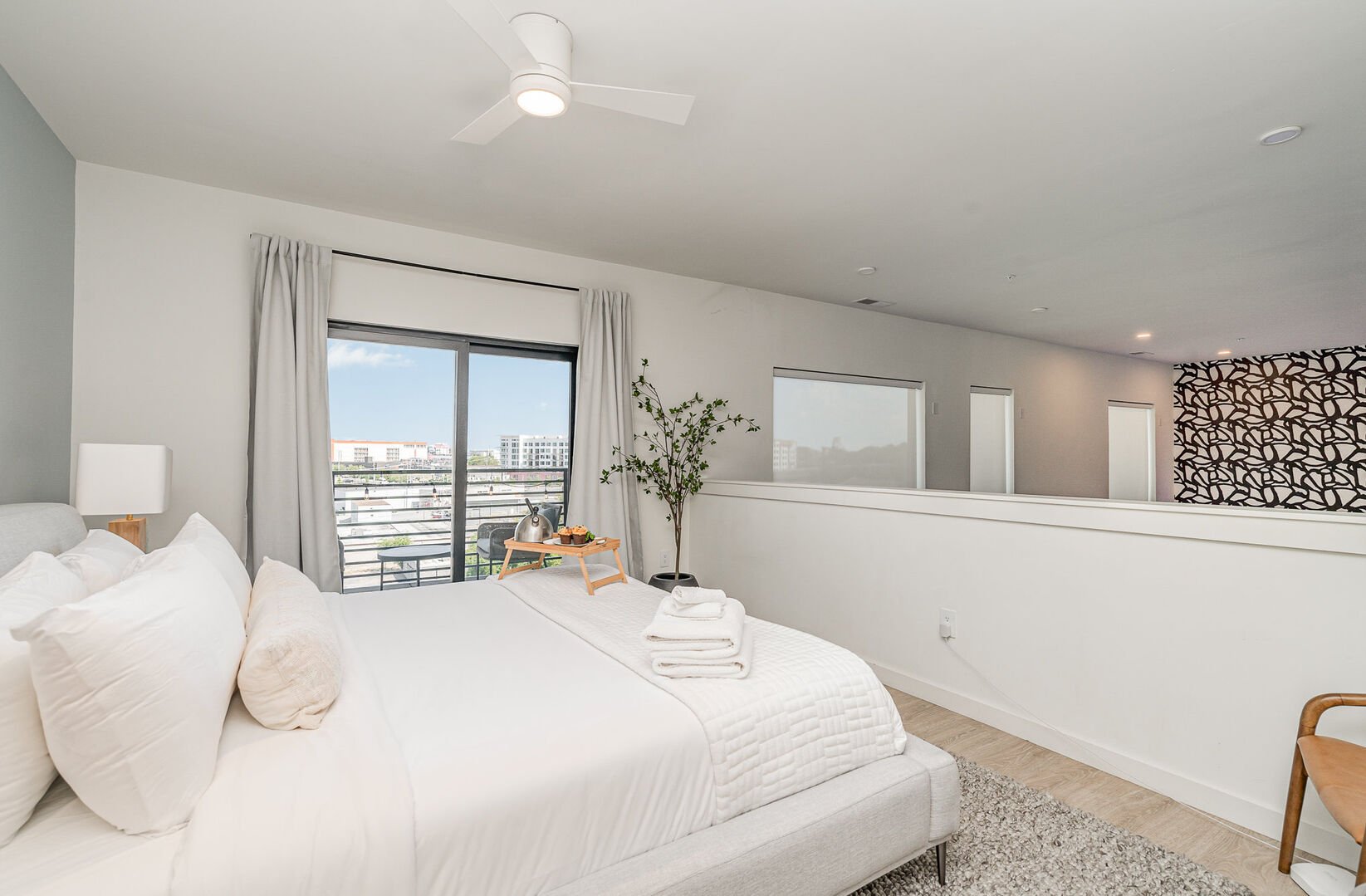 Upper Level: Primary bedroom with King bed, en-suite bathroom, walk-in closet, and its very own private balcony. The bedroom overlooks the living area.