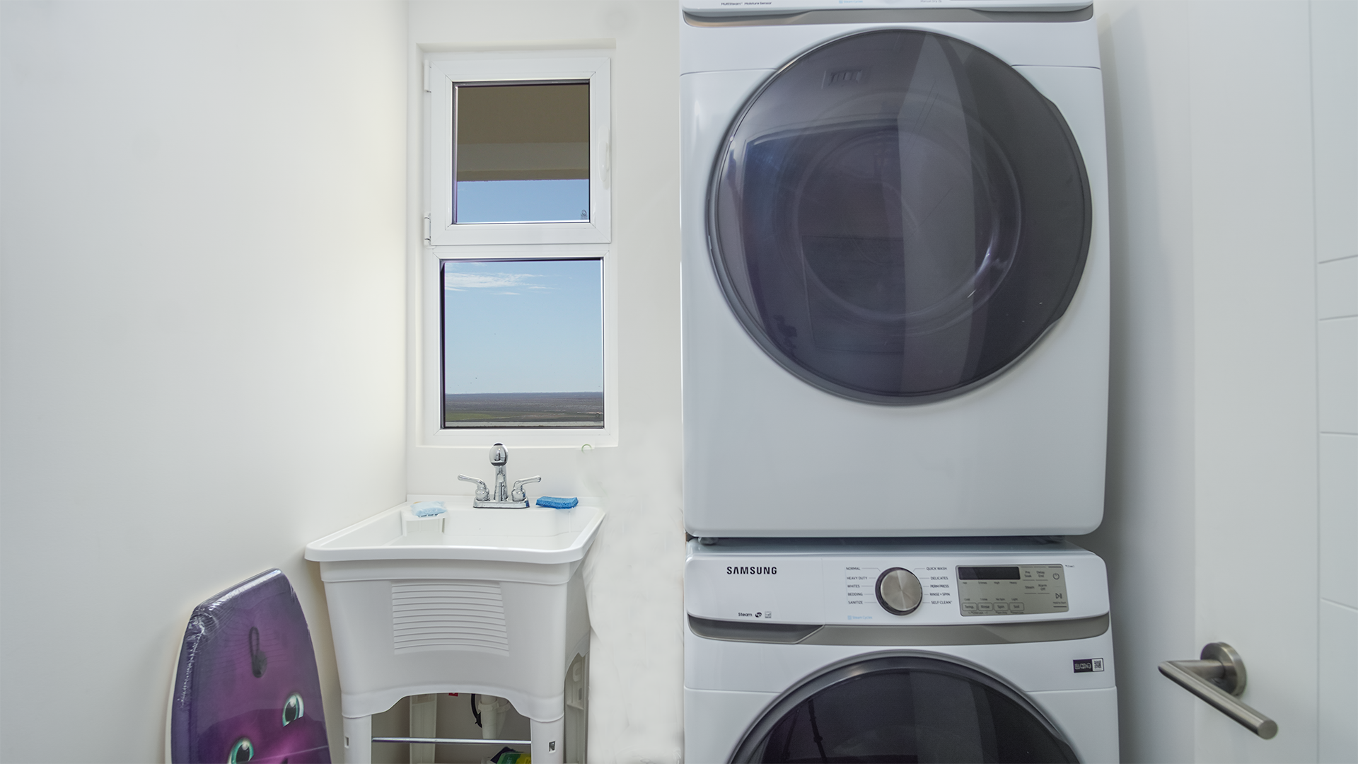 Utility space brings together a washer and dryer, sink, and space for more storage.
