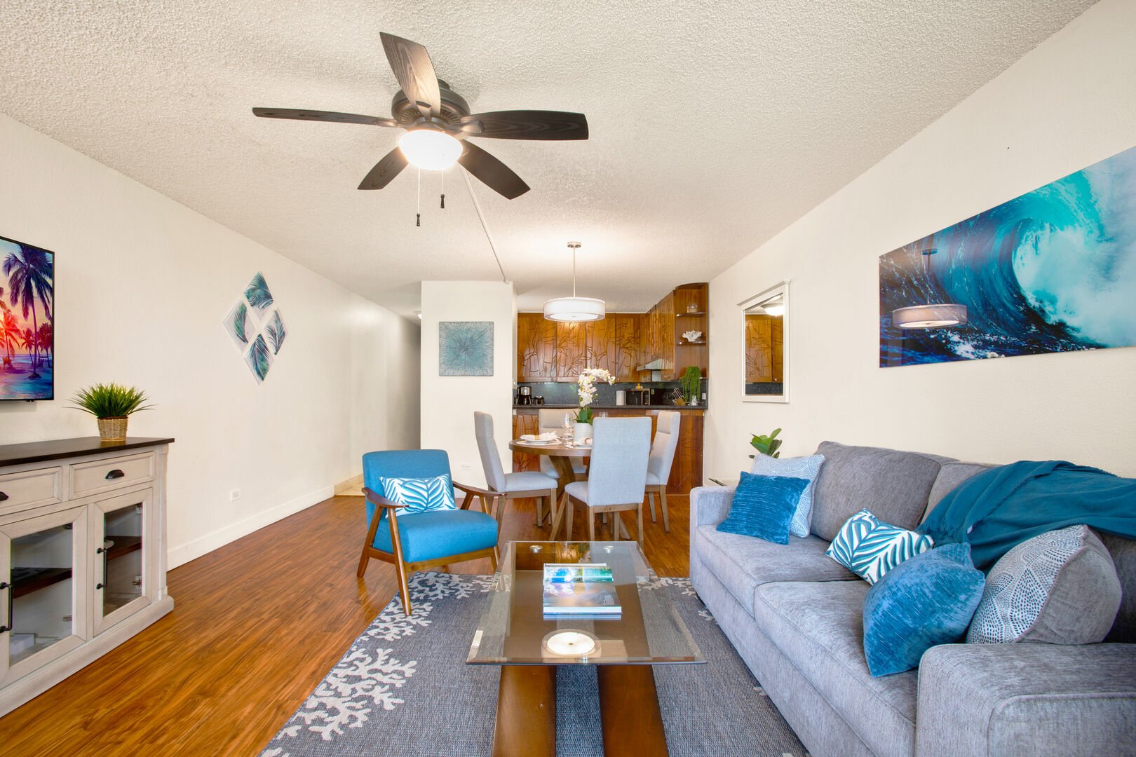 The living room boasts a queen-size sleeper sofa, coffee table, 1 chair, flat screen TV, and ceiling fan with light!