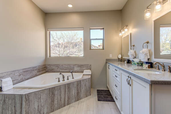 En Suite Master Bath with Dual Stone Counter Sinks and a Soaking Tub