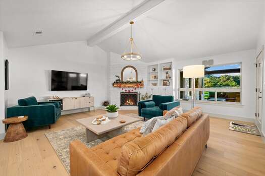 Living room with leather furnishings, smart TV, and gas fireplace