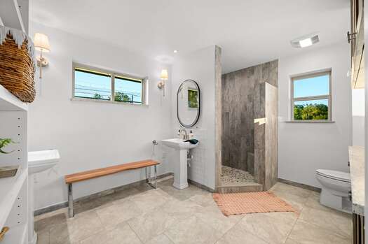 Master bathroom with two pedestal sinks and gorgeous tiled walk-in shower