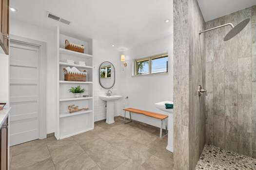 Master bathroom with two pedestal sinks and gorgeous tiled walk-in shower