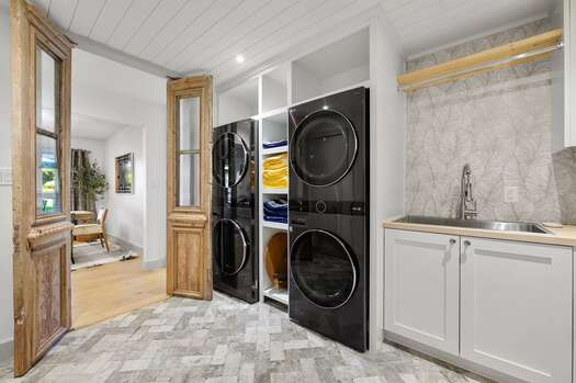 Laundry room with two sets of stacked washer/dryers