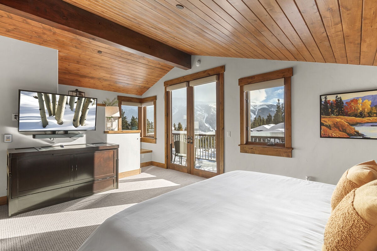 Relax in the grandeur of the Main Master Bedroom, featuring a King Bed with plush bedding and vaulted timber ceilings, a royal retreat.