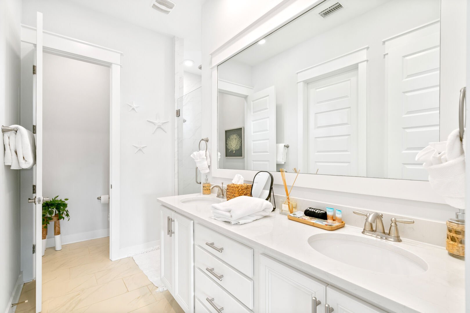 Primary bathroom comes equipped with dual vanities, walk-in closet, and large rainfall shower.