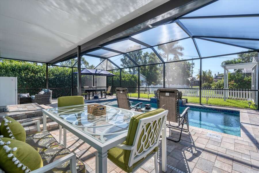 Spacious outdoor area with dining table overlooking the pool