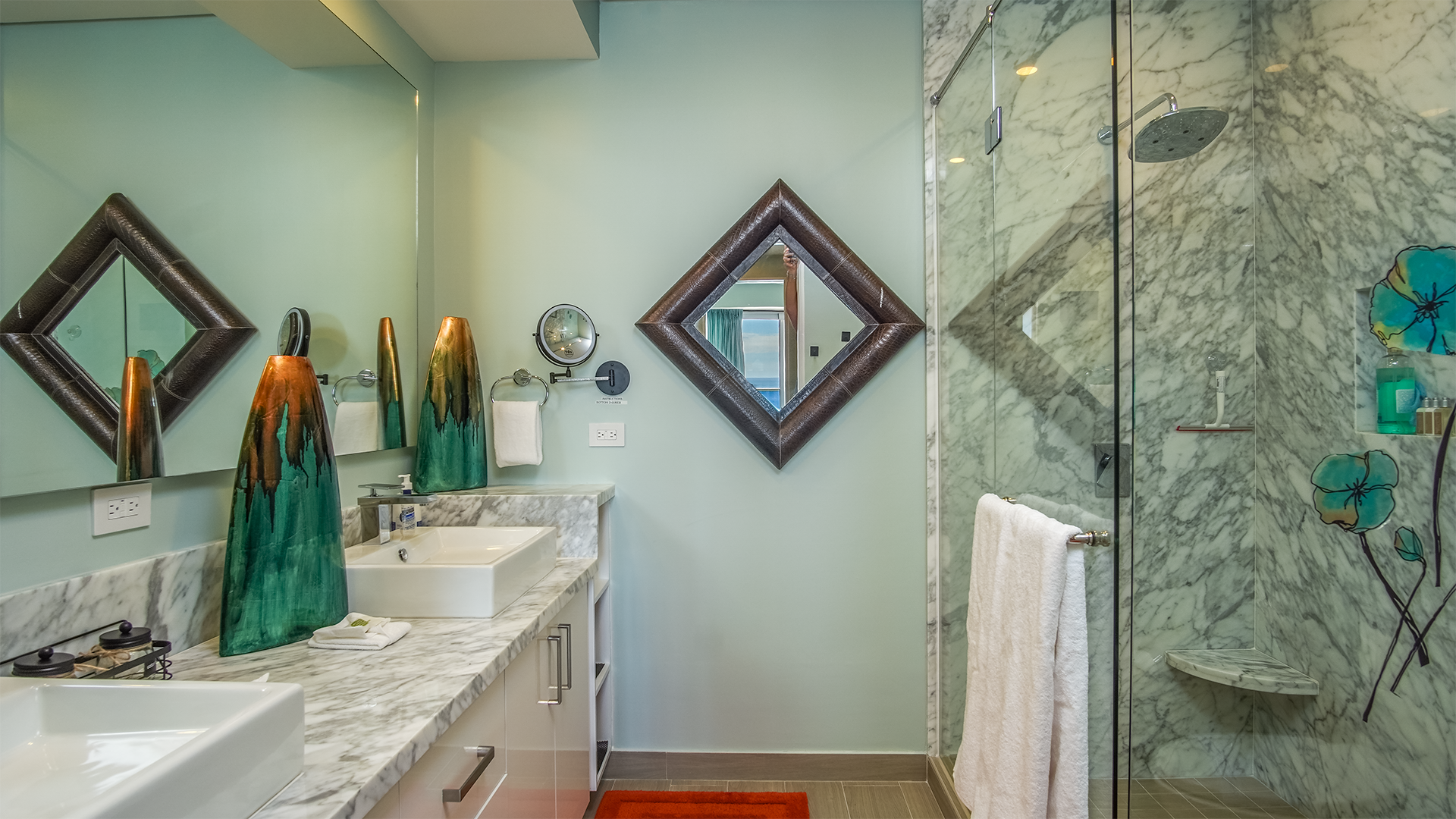 Enter the main bathroom. Exquisite marbled glass shower. and marbled double sink vanity with a full wall of illuminated mirror.