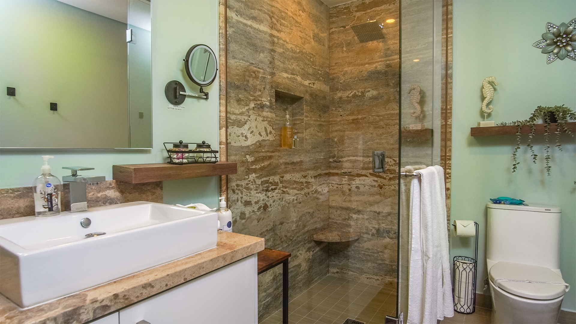 The marbled shower and vanity of the second bathroom, connected directly to the second bedroom.