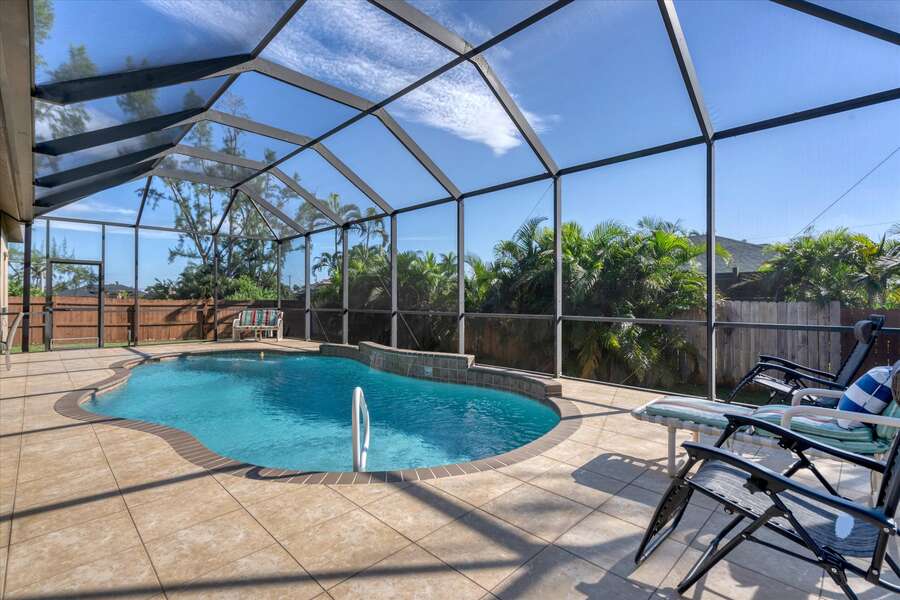 Covered lanai with beuatiful pool and plenty of dining and seating space