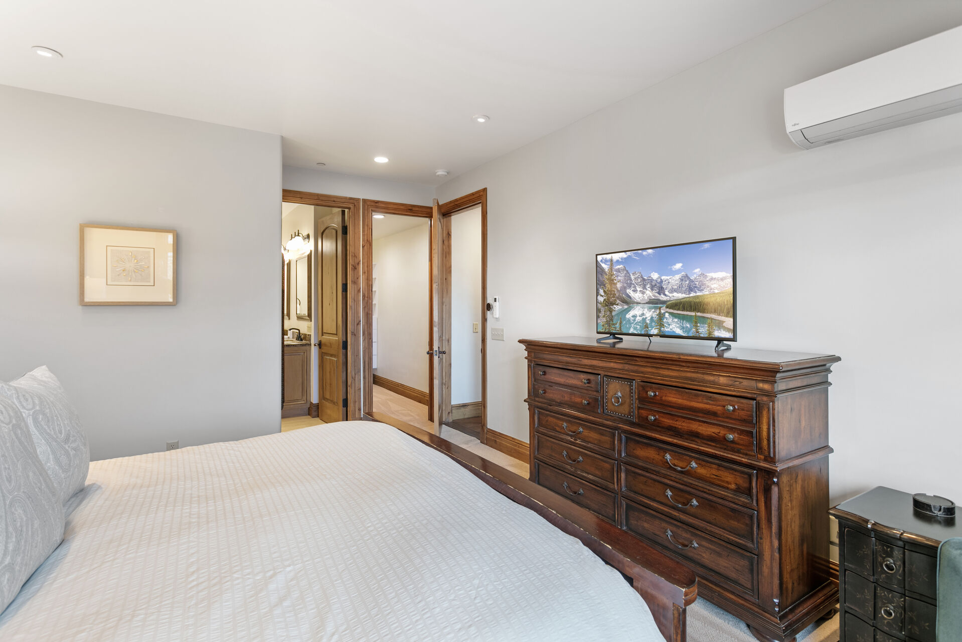 Master bedroom with dresser and flatscreen Smart TV