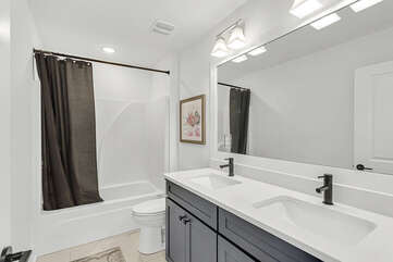 Full bathroom with double vanities tub and shower combo