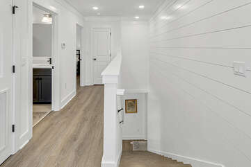 Spacious hallway leading to additional bedrooms and bathrooms