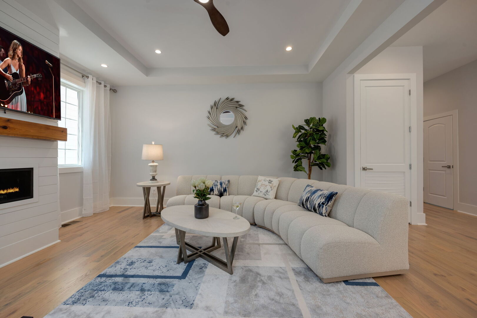 (1st Floor) Spacious living room with multiple seating, smart TV, and fireplace.