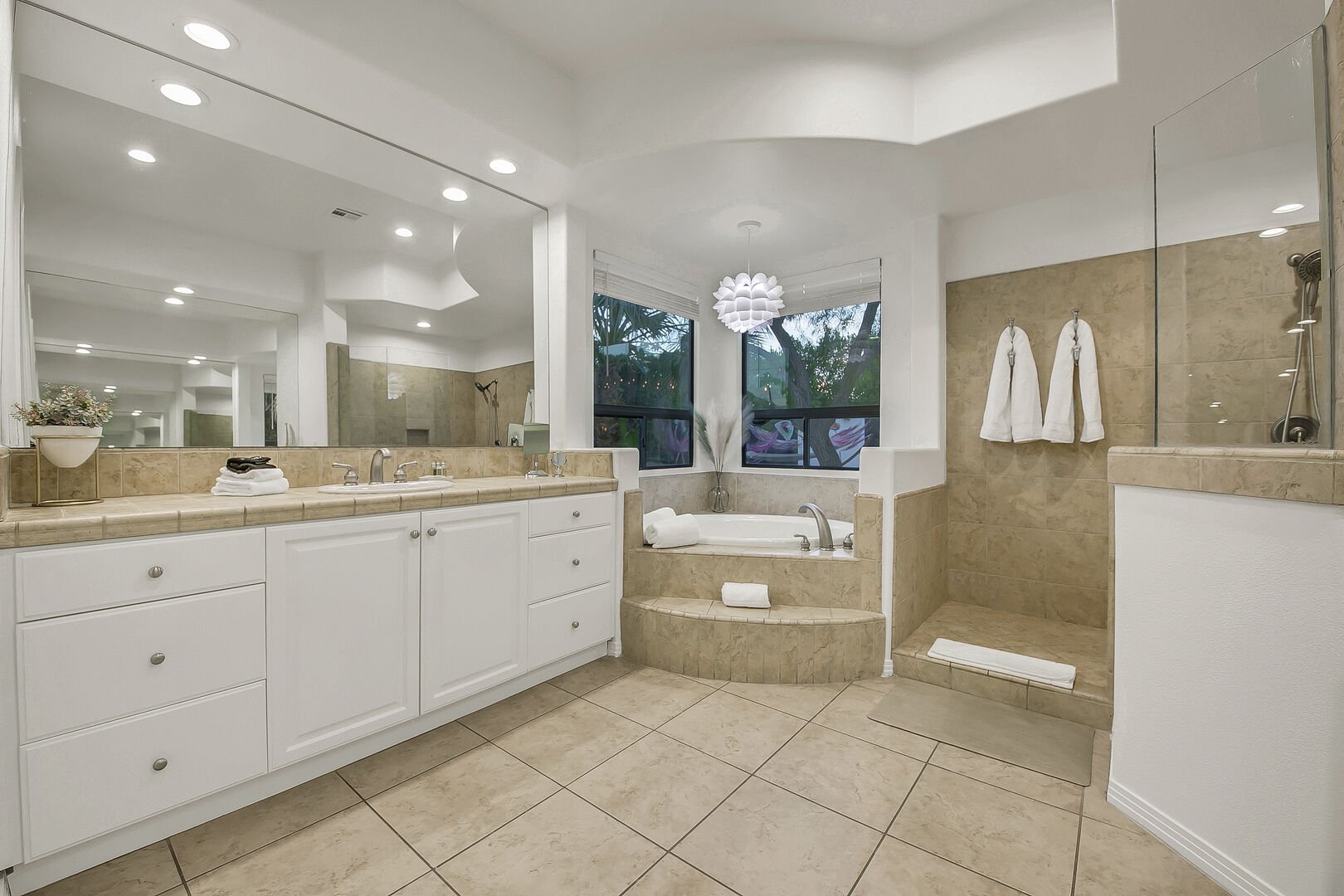 The private en suite master bathroom features a soaking tub, tile shower and his and her vanity sinks.