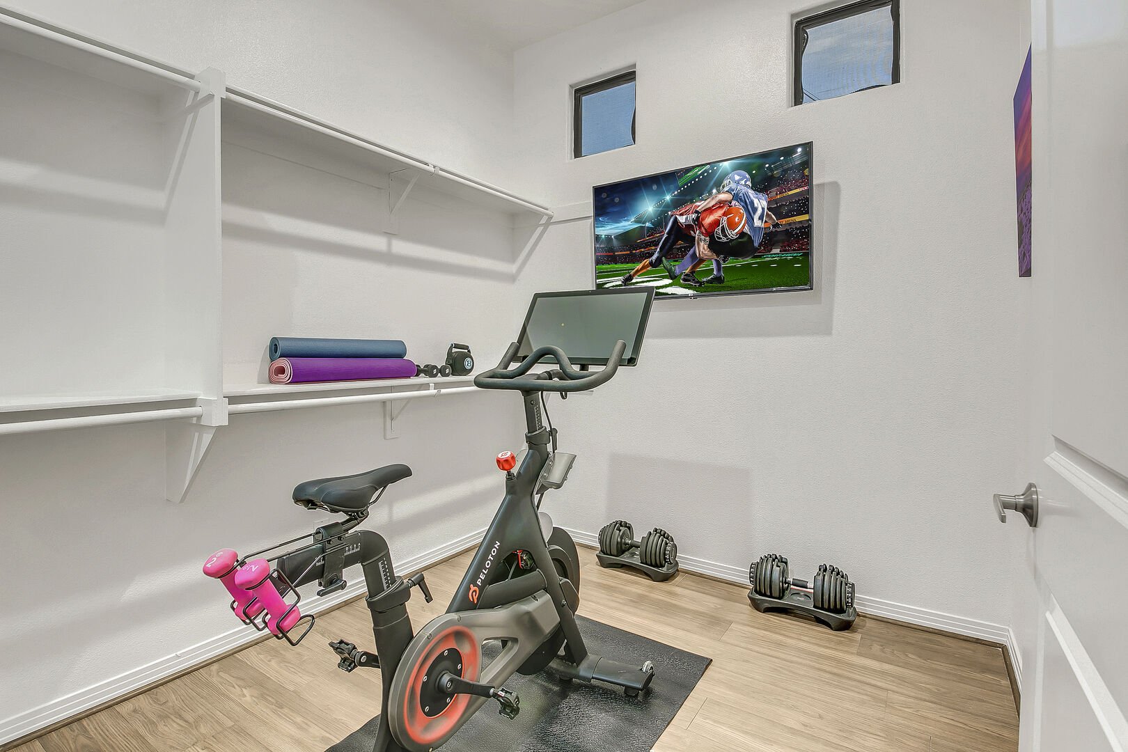 Master bedroom has an exercise room with a Peloton bike, adjustable weights, two yoga mats, and 48 inch LG TV.