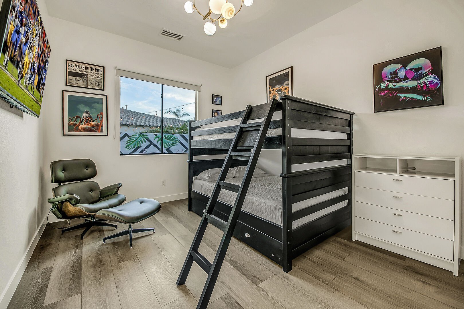​​​​​​​Bedroom 5 features a Full Over Full with Twin Trundle Bunk Bed, 55-inch TCL with Roku Smart television, decorative planet light fixture, and reach-in closet.