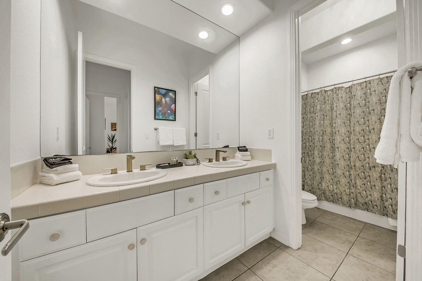 The hallway bathroom features a bathtub and shower combo and two vanity sinks.