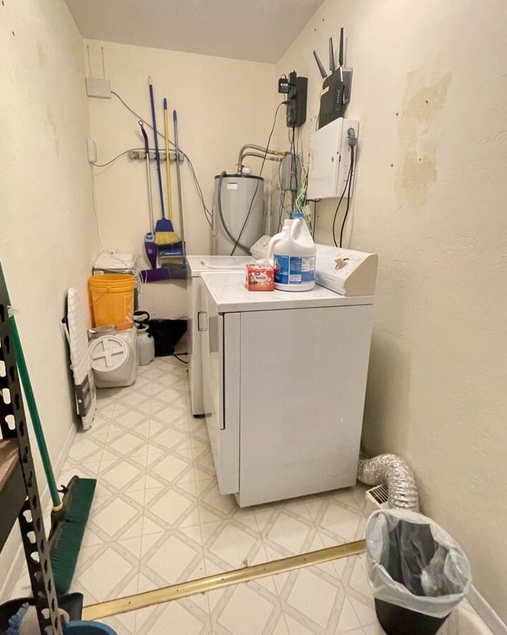 Laundry room with cleaning supplies and washer and dryer for extended stays.