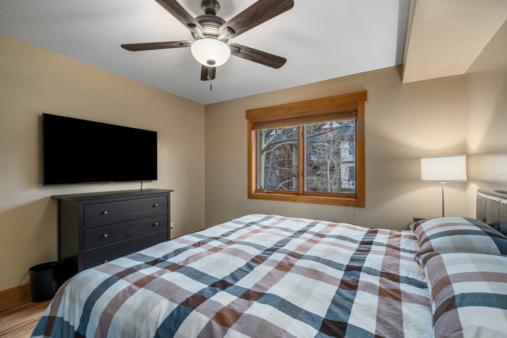 TV and ceiling fan are added comforts to the bedroom