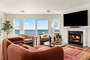Bright and spacious living room with ocean views, flat screen TV and fireplace