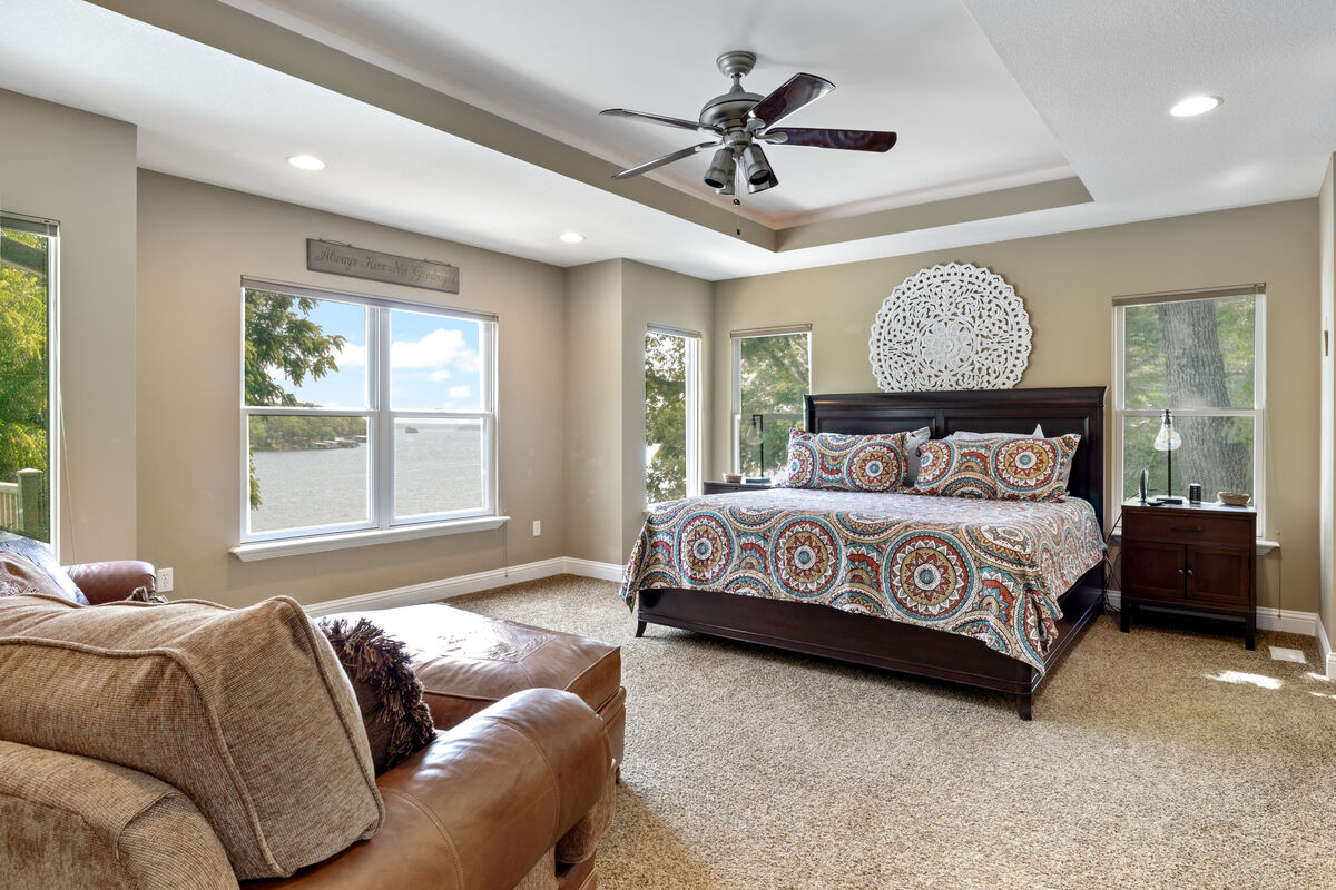Embrace the coziness and charm of the master bedroom, nestled in a picturesque lake view setting.