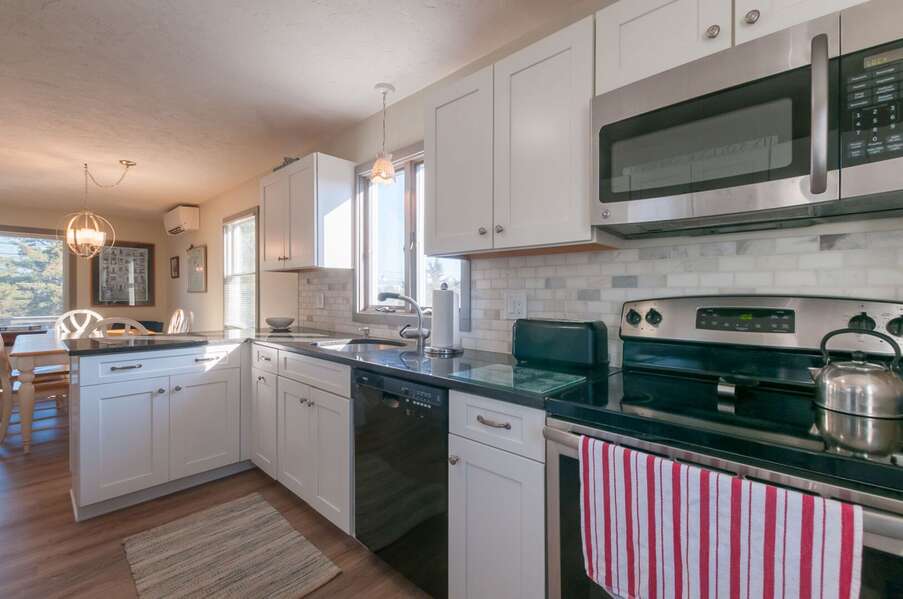 Fully equipped kitchen with dishwasher, toaster, and kettle.