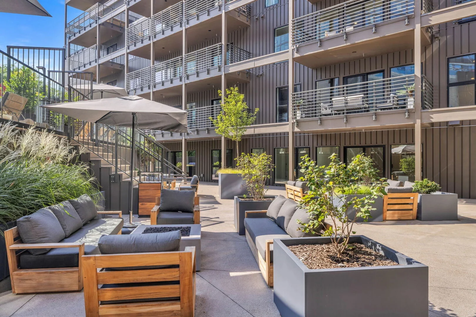 Communal Area: Outdoor furnishings for lounging with a fire pit, ping pong, and a built-in BBQ grill with an outdoor island offering bar seating.
