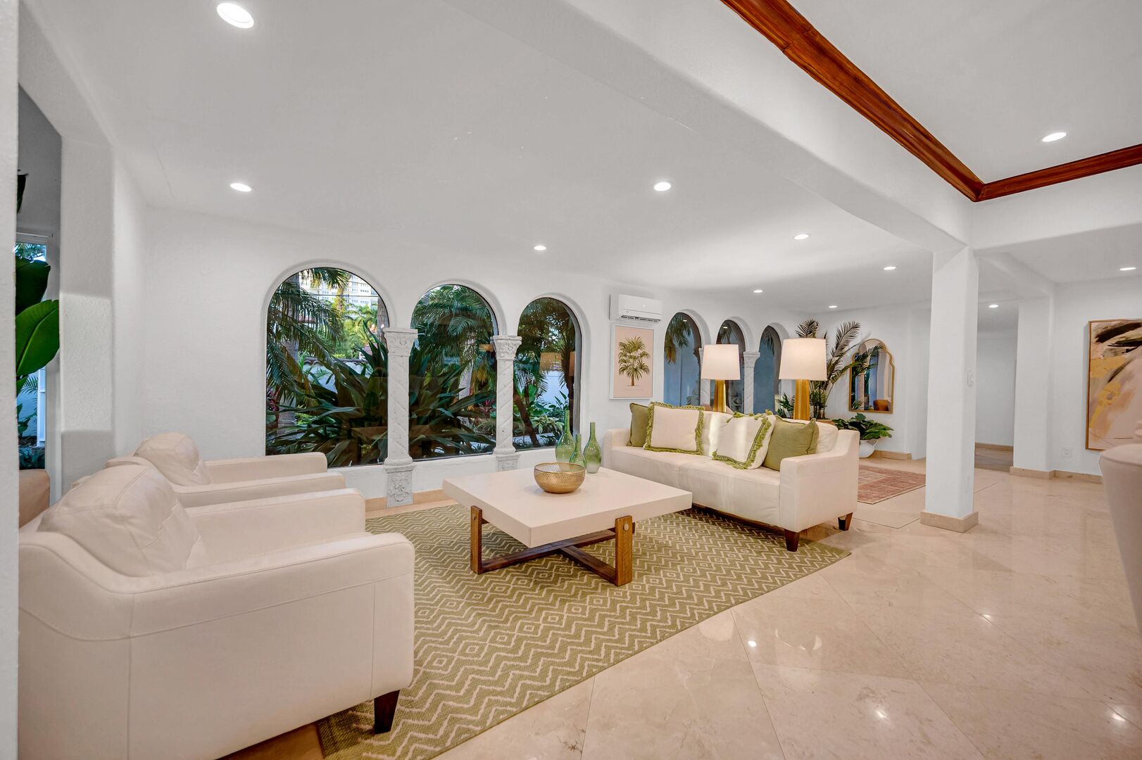 The living area features garden view through arched windows.