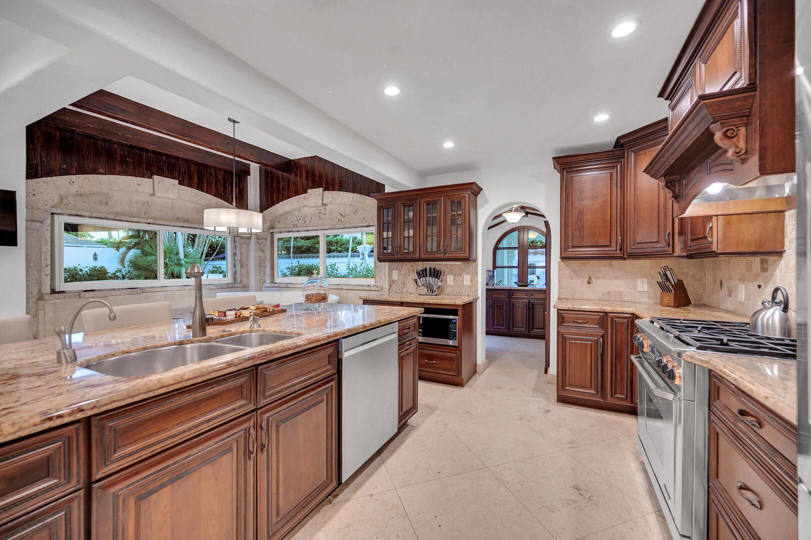 The open gourmet kitchen features bar seating for three and a pantry.