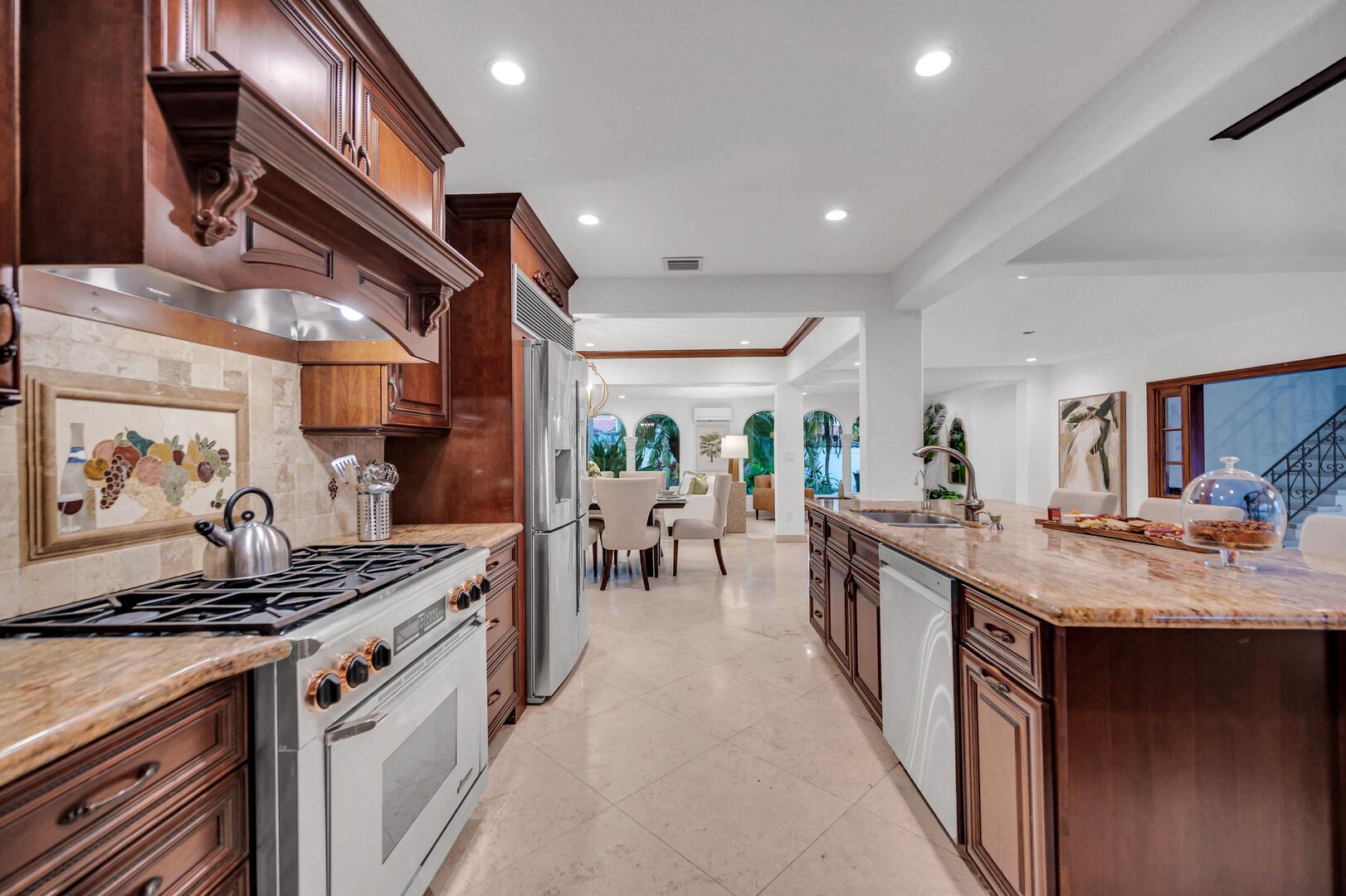 The open gourmet kitchen features bar seating for three, a breakfast nook overlooking the heated pool.