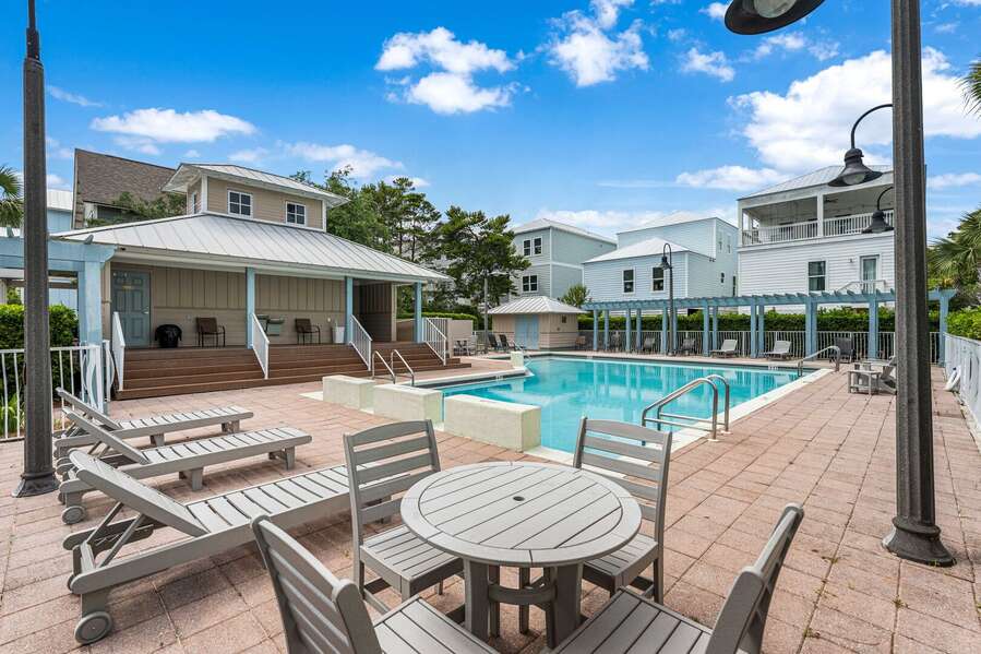 Gated community pool just a few steps away with streaming waterfalls, restrooms, plenty of seating, and lounge chairs.