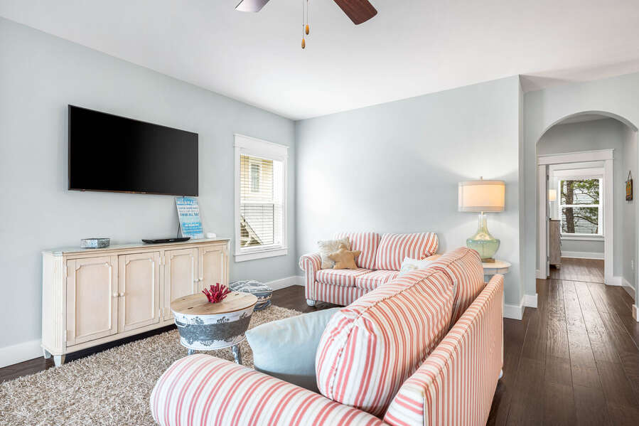 Gathering room on the second floor with a sofa sleeper, flat screen tv, bistro table with seating for 4, foosball table and balcony with seating.