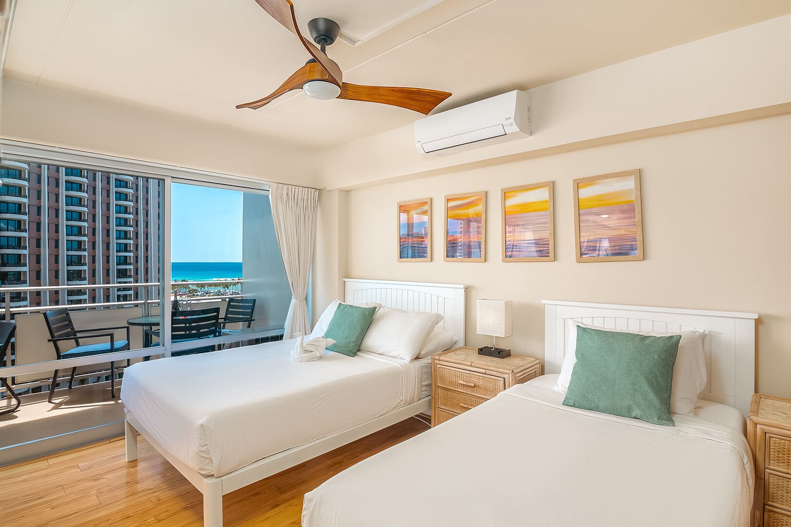 The second bedroom with 1 full-size and 1 twin-size bed, a ceiling fan, split AC, and a beautiful ocean view.
