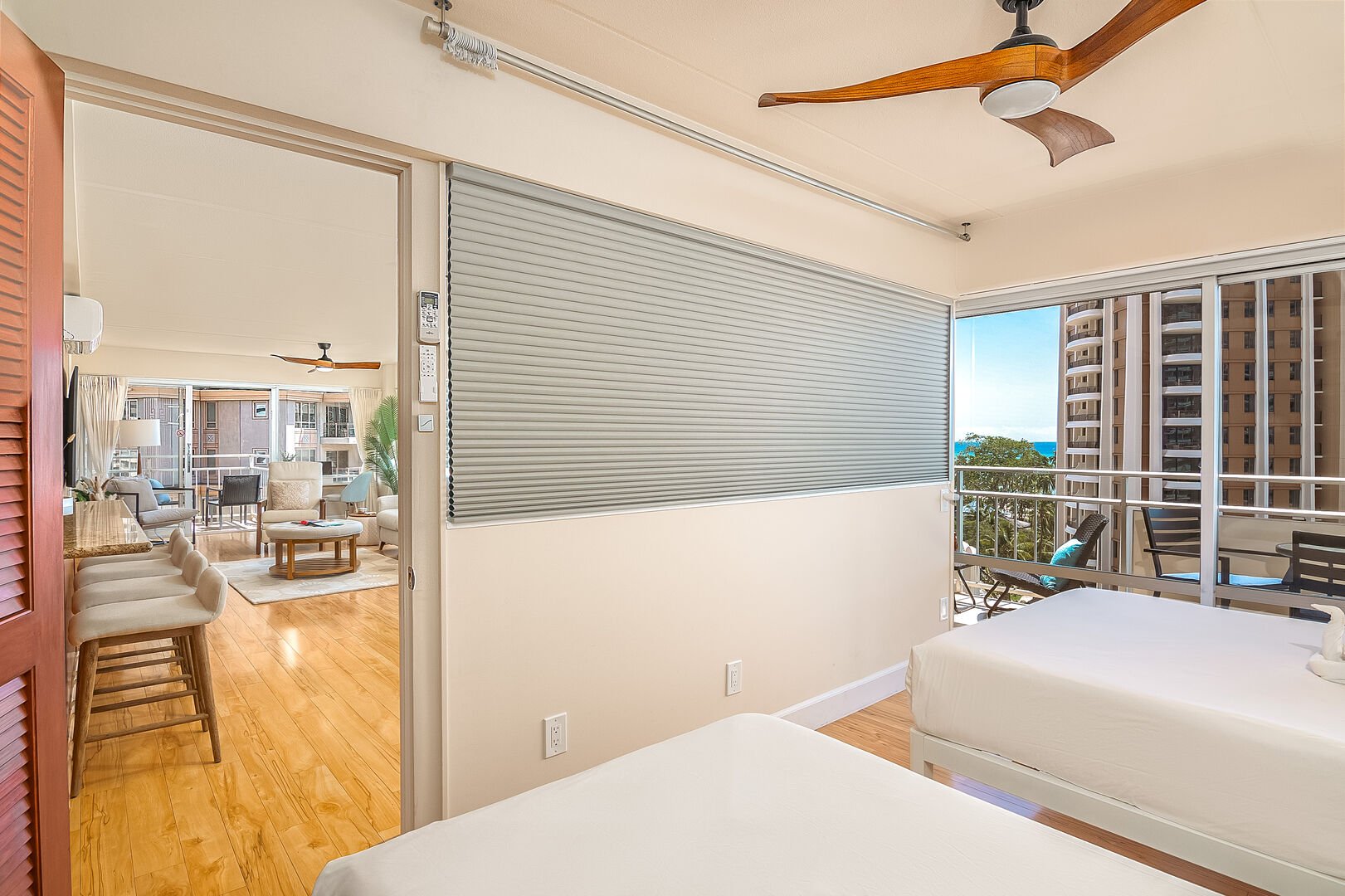 The second bedroom with 2 beds and motorized window blinds offers the option of having privacy or connecting the room and view to the rest of the living space.