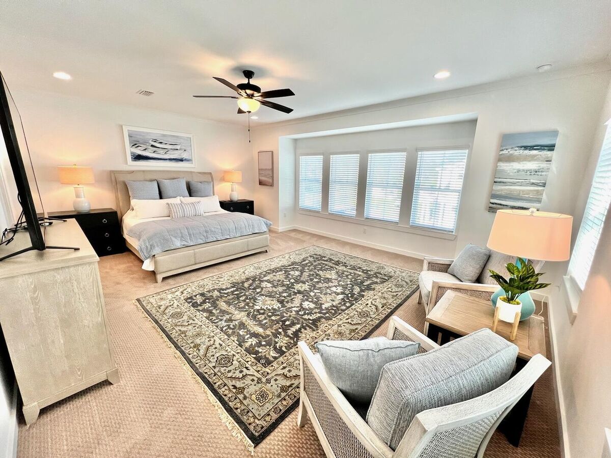 Spacious master bedroom featuring a comfortable seating area and a Smart TV for your enjoyment.