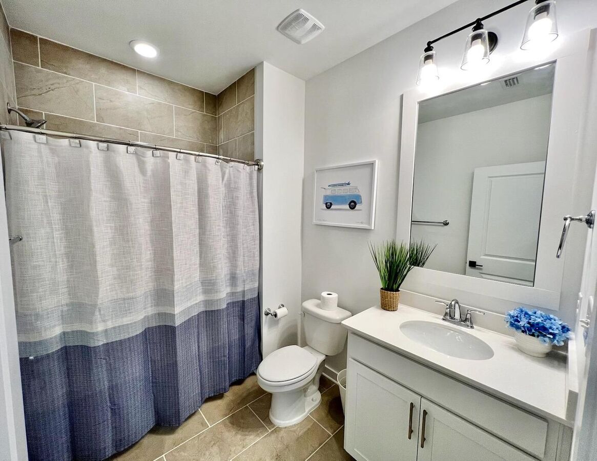 The guest bathroom, which is shared by both guest rooms, features a conveniently placed tub/shower combination at the hallway's end.