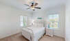 This bedroom is furnished with a comfortable queen size bed and stylish coastal decor. A ceiling fan and Smart TV are provided for your home away from home convenience.