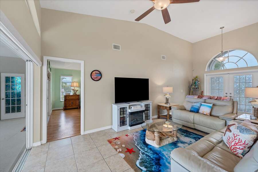 Bright, coloful, open living room with ample seating and 65