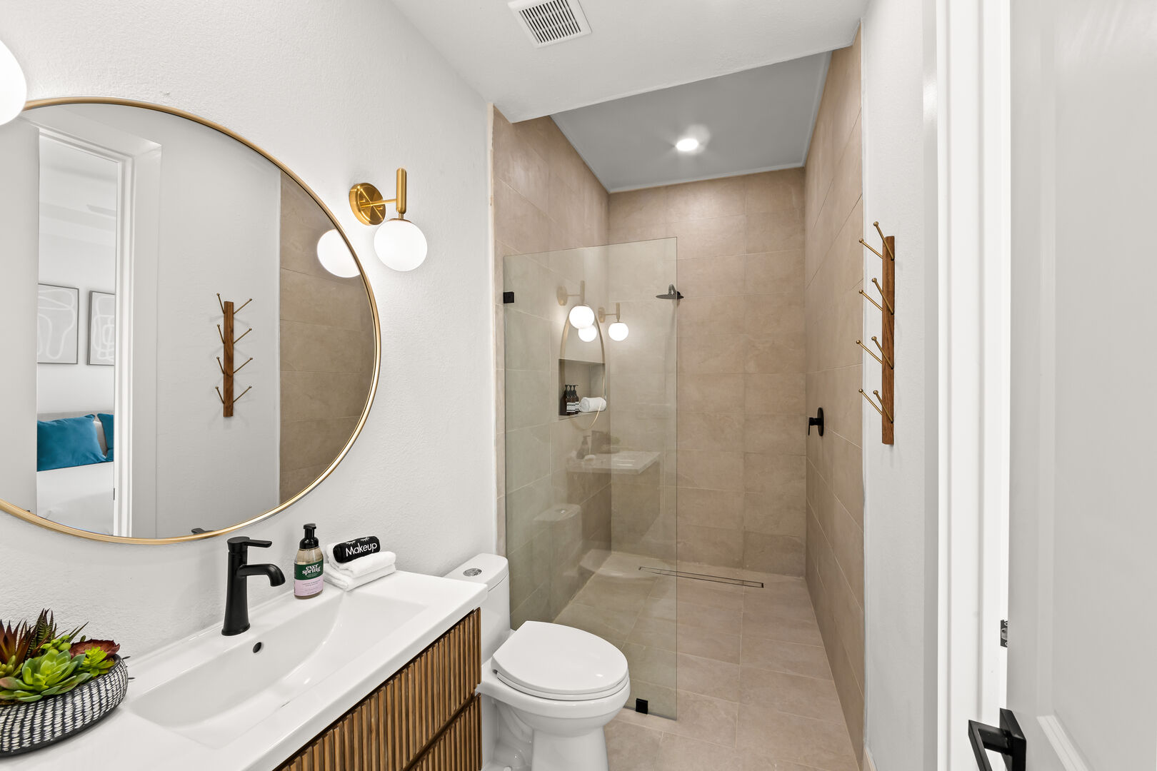 The private ensuite bathroom features two separate doors and may also be utilized as a powder room. This bathroom features a large walk-in tile shower with a decorative floating vanity sink.