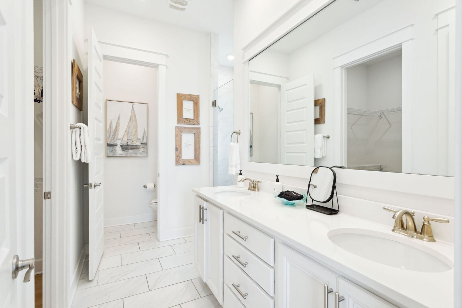 Primary bathroom features double vanities, walk-in closet, and rainfall shower.