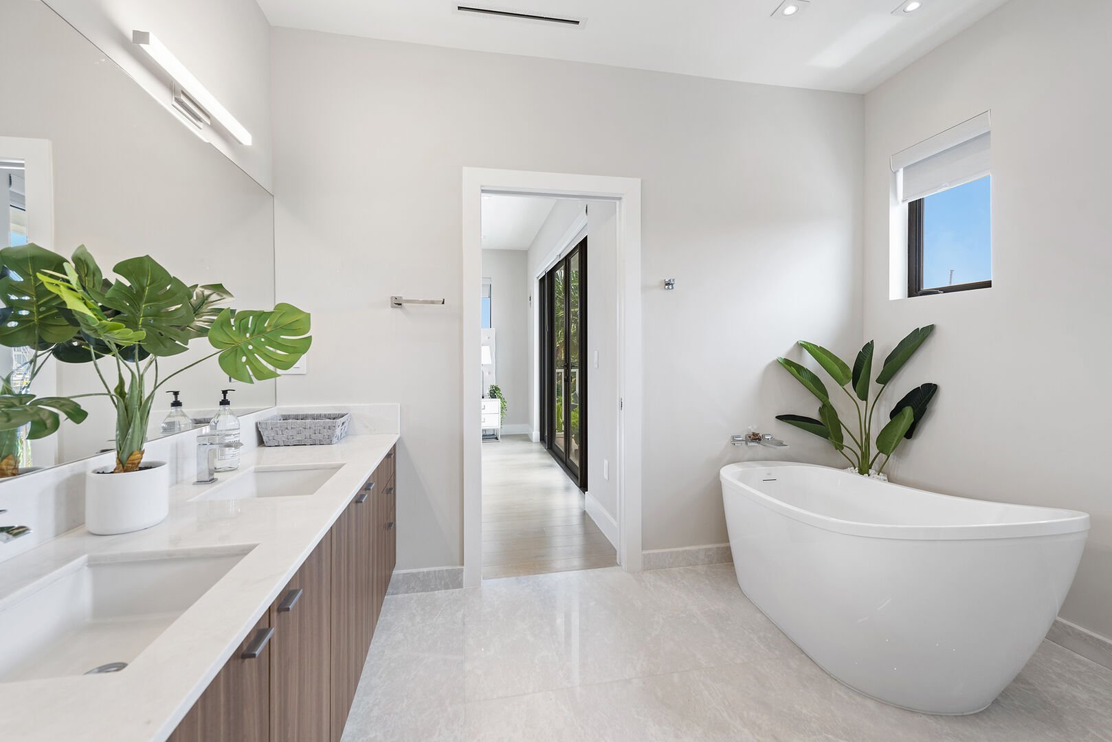 The primary bathroom features a walk-in shower, double sinks and a bathtub. Fiji amenities and Comphy opulent towels.