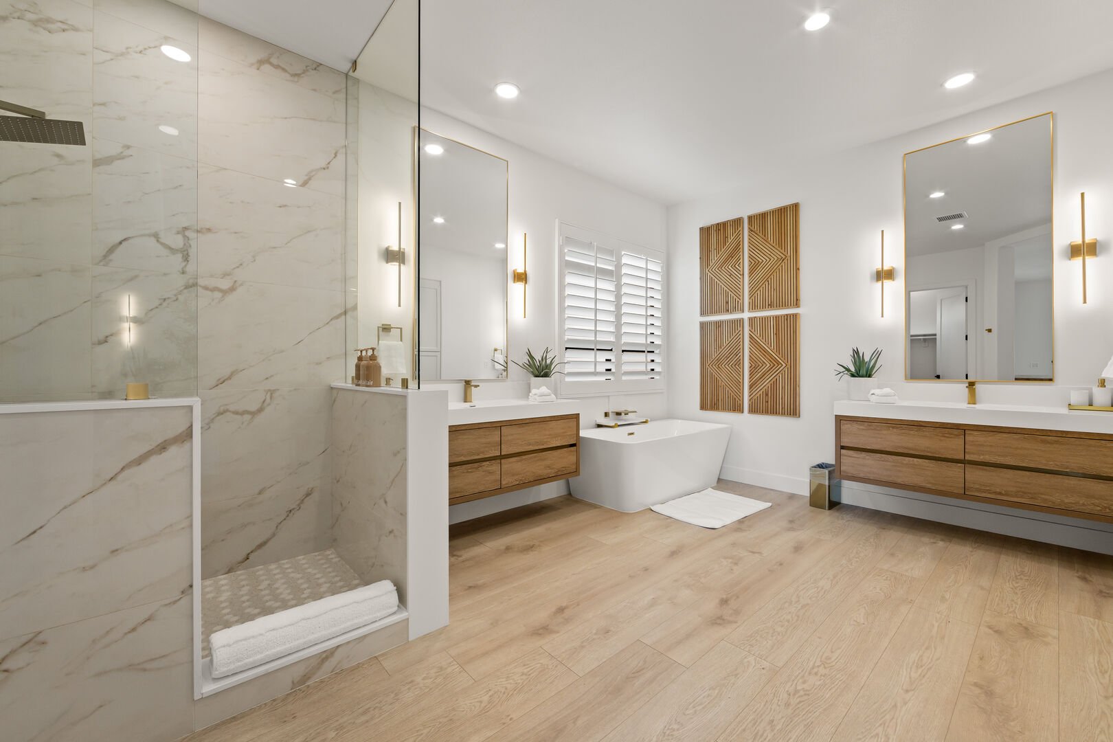 Master Suite 1 private en-suite bathroom boasts a soaking tub, a marble shower that extends up to the ceiling, and his and her floating vanity sinks.