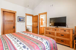 master bedroom on the top level with a  king bed and flat screen tv with ensuite full bathroom and walk in closet