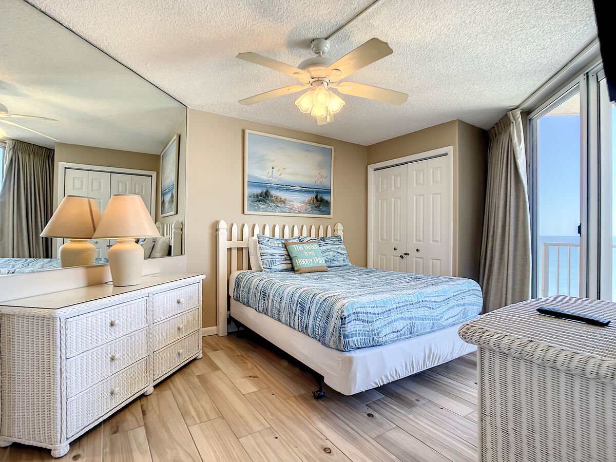 Queen size bed with ceiling fan above.