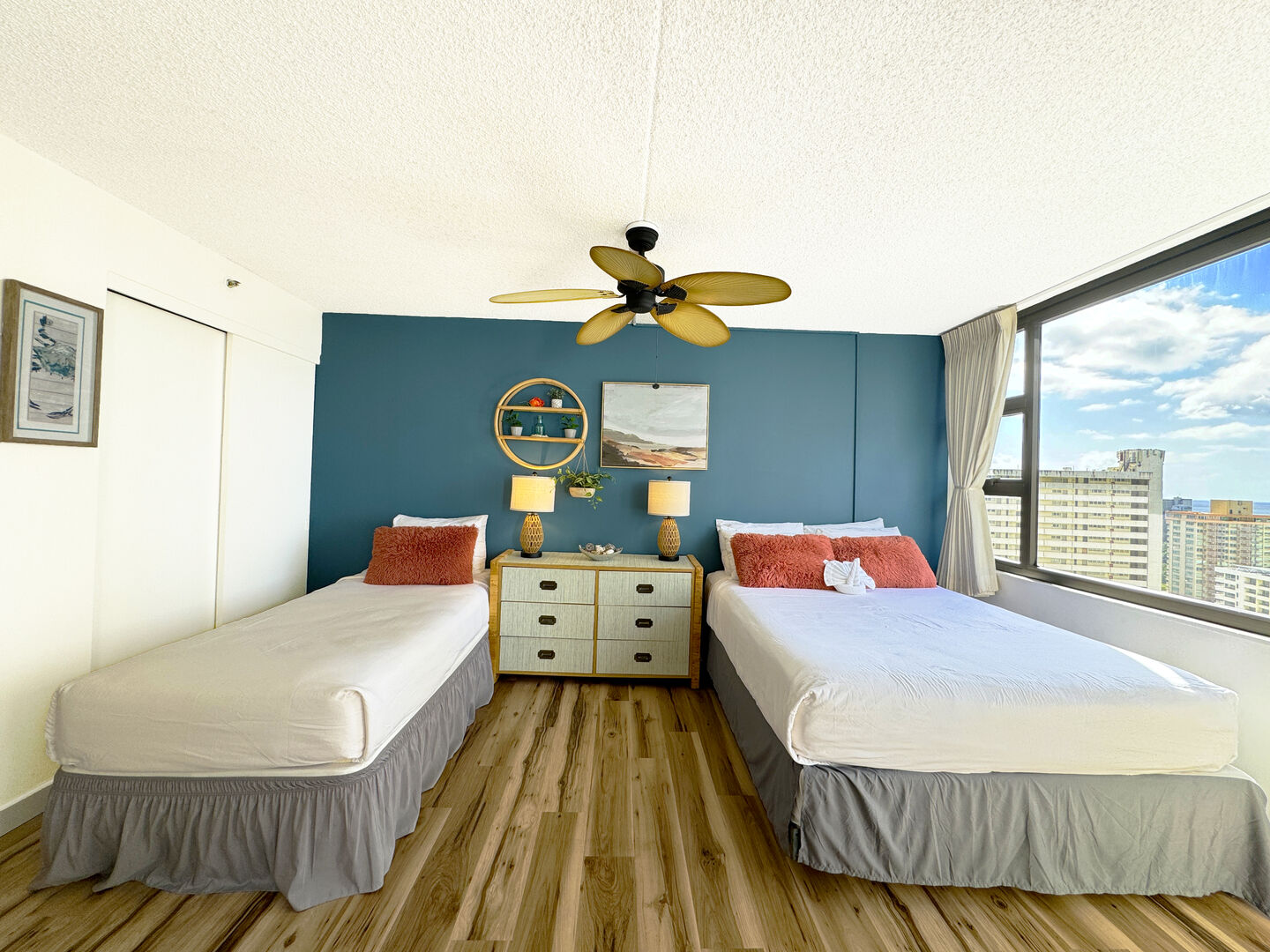 Bedroom with 1 queen-size and 1 twin-size bed, and fan.